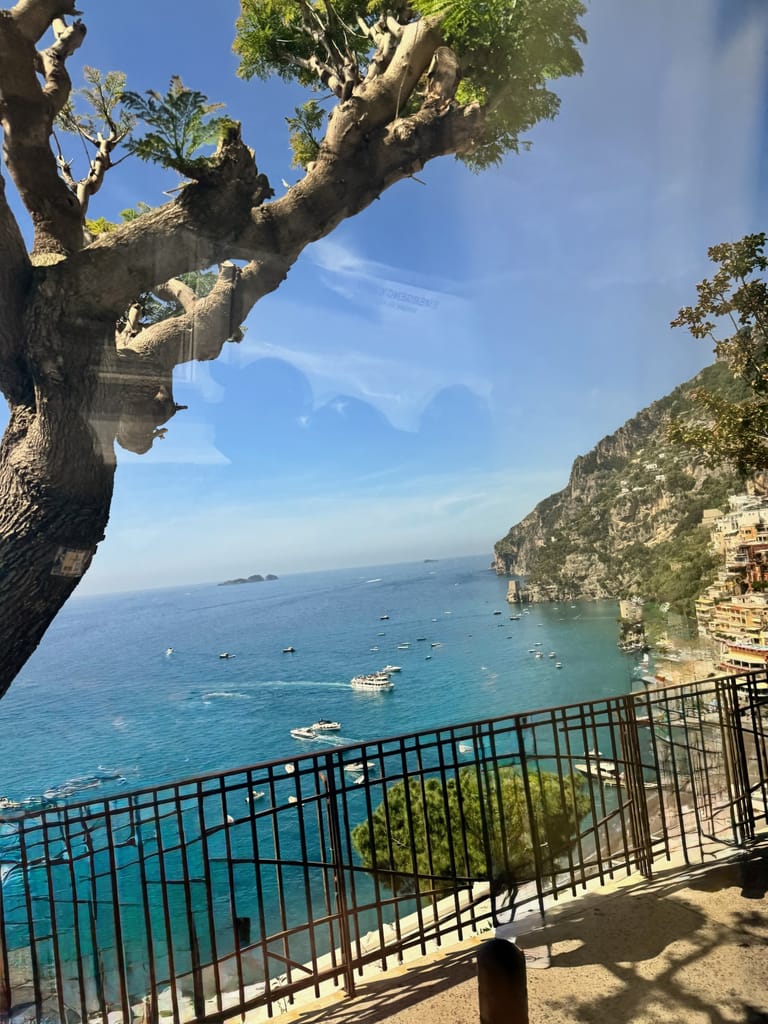 View of the Amalfi Coast with boats on the water and hillside homes